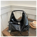 Detail of black patent leather hobo bag with bow decoration and silver metal hardware - Black