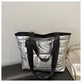Detail of silver puffer tote bag showing quilted texture and shiny metallic finish - Silver