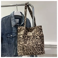 Close-up of leopard print tote bag with external pocket and durable shoulder straps - Khaki