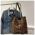 Detail view of large leopard print tote bag with double front pockets and soft suede texture - Brown