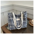 Blue and white patterned canvas tote bag with leather handles on a wooden table - Blue Without Charm