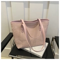 Light pink tote bag with pleated texture and metal studs on a minimalist chair - Pink