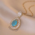Élégant collier en or 18 carats avec pendentif en zircon bleu sur soie champagne - Bleu Saphir