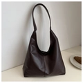 Detail of a large dark coffee hobo tote bag with a wide strap on a beige table - Dark Brown