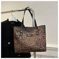 Detail of leopard print tote bag with gold logo plaque and black shoulder straps - Brown