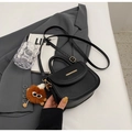 Black pebbled leather handbag with gold bar and brown plush monster charm accent - Black (With Charm)