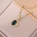 Collana di zirconi smeraldo dorati in una scatola di gioielli in raso rosa - Collana in Zirconia Verde Smeraldo (X1643)