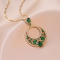 Vista macro de collar dorado con circonitas verde esmeralda y colgante redondo calado - Collar Verde Esmeralda (X1650)