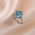 Adjustable silver ring with four blue zircon baguettes in a cross pattern on silk fabric - Blue Adjustable Ring (J150)