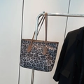 Grote shopper met luipaardprint en bruine leren handvaten aan een kledinghanger - Zwarte Luipaard