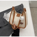 Close-up of retro cream square bag with brown trim and cute plush doll pendant - With Charm / Off White