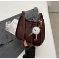Detail of dark brown saddle bag with double shoulder straps and white plush monster charm - With Charm / Brown