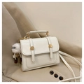 Detail of cream white leather handbag with gold buckle and fluffy monster charm - White with Pendant