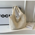 Detailed shot of a cream-white textured tote bag showing unique quilted fabric and soft handle - Off White