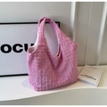 Macro view of pink textured fabric tote bag with pleated pattern and soft crescent structure - Pink