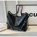 Detailed shot of large black tote bag with silver zippers and buckle details - Black