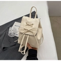 Chic beige mini backpack in faux leather featuring a decorative front bow and slim straps - Off White