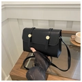 Detail of a minimalist black faux leather crossbody bag with a gold buckle and strap - Black