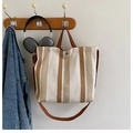 Gestreifte Canvas-Einkaufstasche in Braun und Beige mit Schultergurt in Lifestyle-Szene - Braun