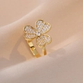Goldener Kleeblatt Ring mit Zirkonia-Besatz auf elegantem beigefarbenem Seidenhintergrund - Pave-Zirkonia-Kleeblatt-Stil (J0151)
