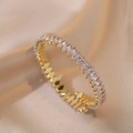 Detailed macro view of 18K gold-plated oval zircon bracelet on champagne silk fabric - White Zirconia (TS165)