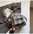 Detail eines karierten Tweed-Rucksacks mit Vintage-Textur und Monster-Plüschanhänger - Blau mit Anhänger