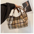 Dettaglio della borsa tote a quadri con trama in tweed e manici in pelle marrone - Griglia Marrone