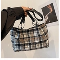 Dettaglio della borsa tote in lana a quadri con manici in pelle e anelli in argento - Quadri Neri