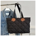 Detail van zwarte gewatteerde shopper met ruitpatroon en lederen bloemvormige accenten - Zwart