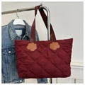 Detail van de bordeauxrode gewatteerde tote bag met ruitpatroon en bloemaccent - Rood