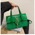 Detail of green handbag showing crocodile texture panel and gold SS metal logo charm - Green