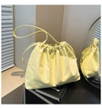 Bolso tipo cubo plisado amarillo pálido con cordón y detalle de lazo plata - Amarillo