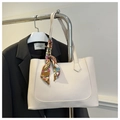 Dettaglio della borsa tote crema con foulard di seta sul manico e blazer nero - Bianco