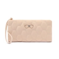 Detail of beige quilted wristlet wallet featuring hexagonal patterns and gold bow clasp - Apricot