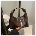 Detail of dark brown glossy hobo bag with gold metal buckle and embossed lettering - Brown