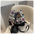 Detail of floral drawstring bucket bag with leather base and elegant gold hardware - Black