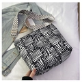 Detail of black and white striped tote bag with floral strap on blue denim jacket - Black