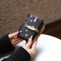 Close-up of black PU leather wallet with mushroom prints and golden brand metal plate - Black