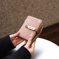 Pink PU leather wallet with mushroom prints and a hand strap shown in hands - Dusty Pink