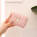 Close-up of pink quilted trifold wallet with gold square buckle and zipper details - Pink