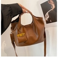 Close-up of brown faux leather tote with lychee texture and mini charm bag accessory - Brown