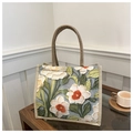 Dettaglio di ricamo floreale rosso e bianco su borsa tote in lino con manici intrecciati - Verde
