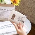 Detail of cream PU leather wallet featuring a cute giraffe print and wristlet strap - Ivory