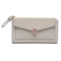 Vista frontal de cartera larga beige tipo sobre con hebilla metálica y asa de muñeca - Verde