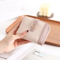 Close-up of pink PU leather wallet with woven texture, D-ring buckle and zipper closure - Pink
