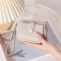 Détail du porte-monnaie en cuir beige avec dragonne et poche à bouton-pression - Abricot