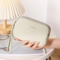 Dettaglio pochette in pelle litchi verde chiaro con doppia cerniera e cinturino da polso - Verde