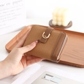 Close-up of woven PU leather wallet with U-shaped gold buckle and smooth zipper - Brown