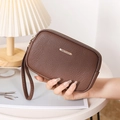 Detailed macro view of brown lychee grain leather wallet with dual zipper and wrist strap - Brown