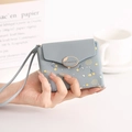 Detalle de billetera de cuero PU azul claro con estampado de bayas, asa y cierre metálico - Azul